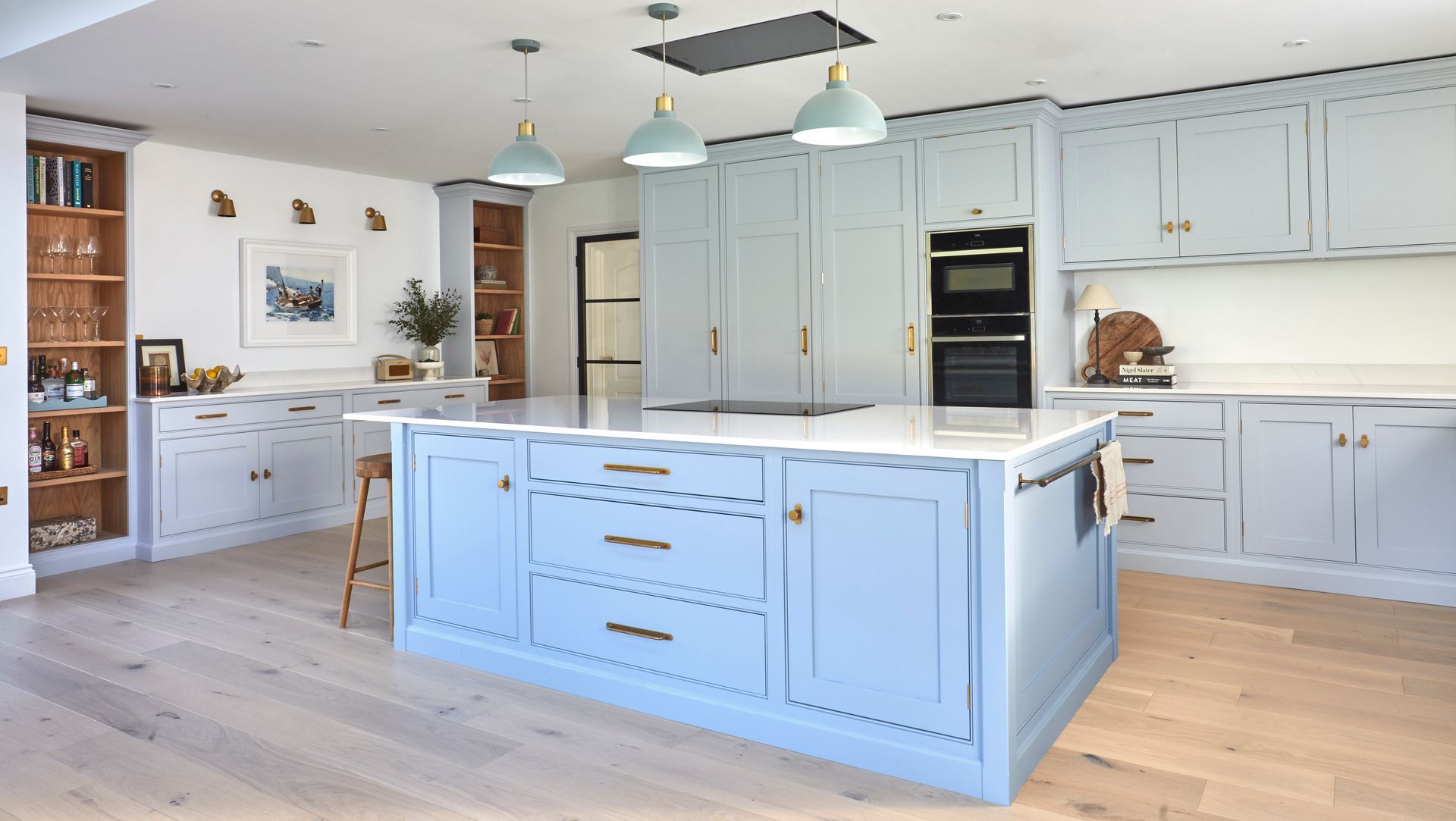 a bespoke kitchen with light blue cabinets and a large island