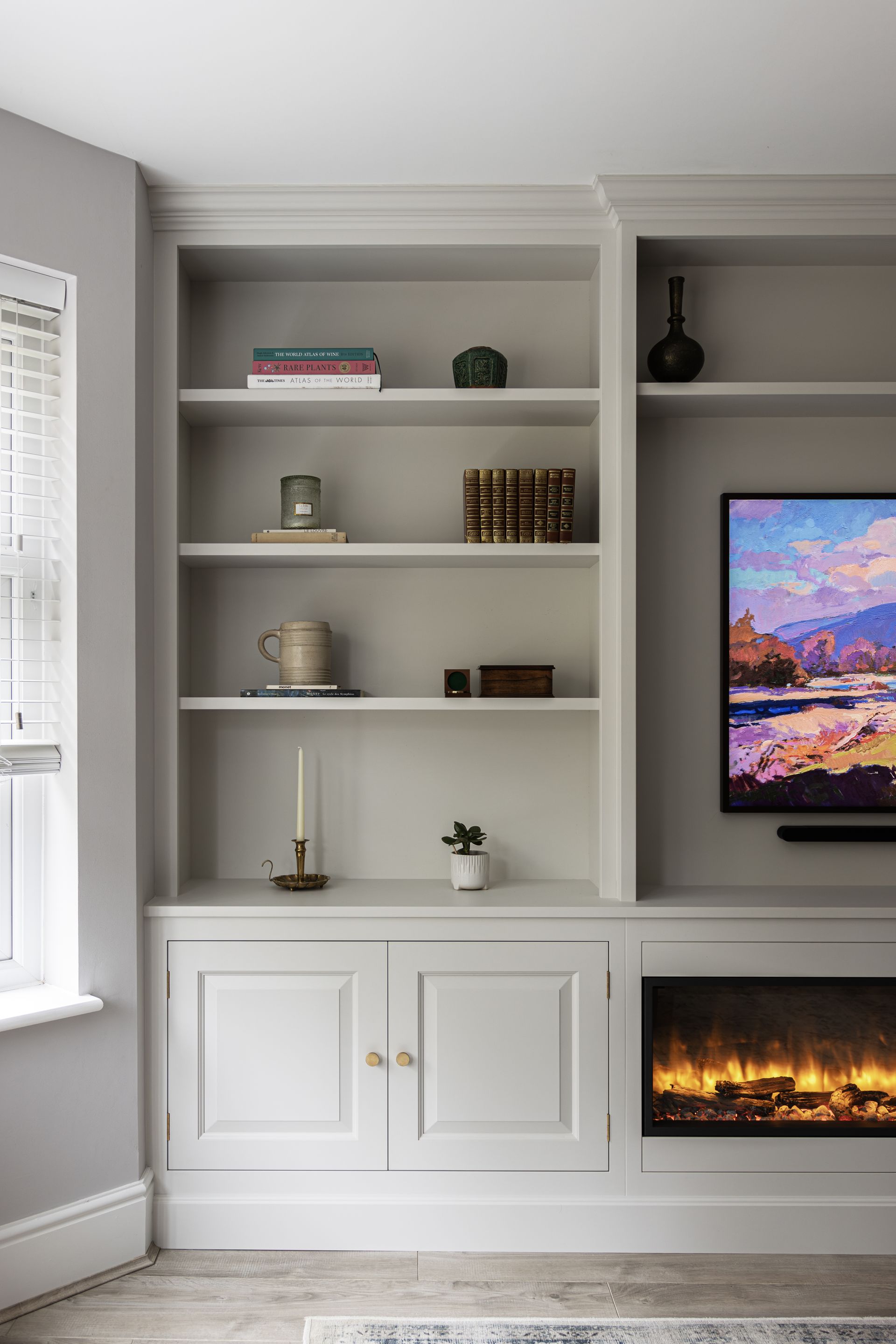 a living room with a fireplace , shelves , and a built in display units