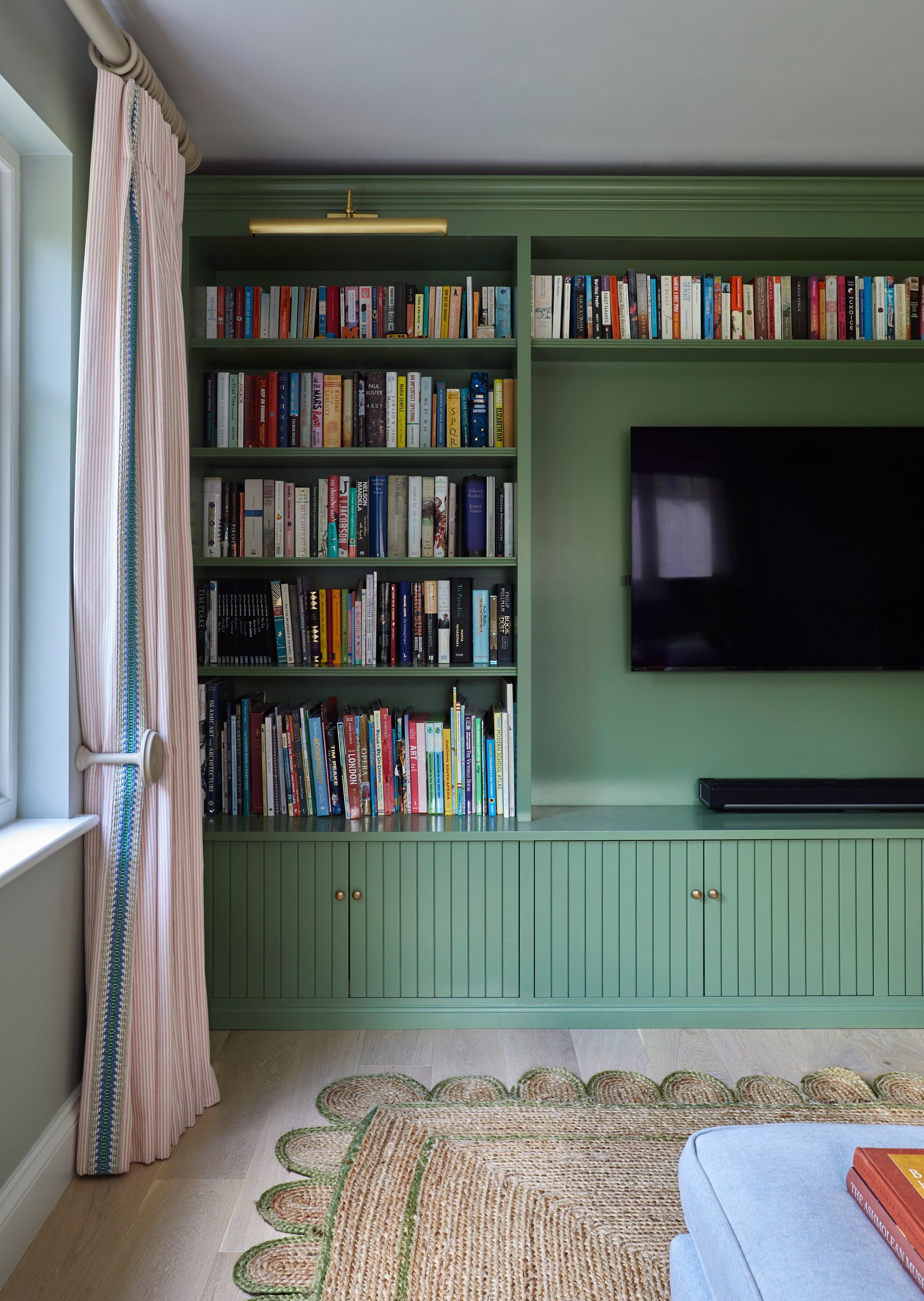 a living room with green custom built home library