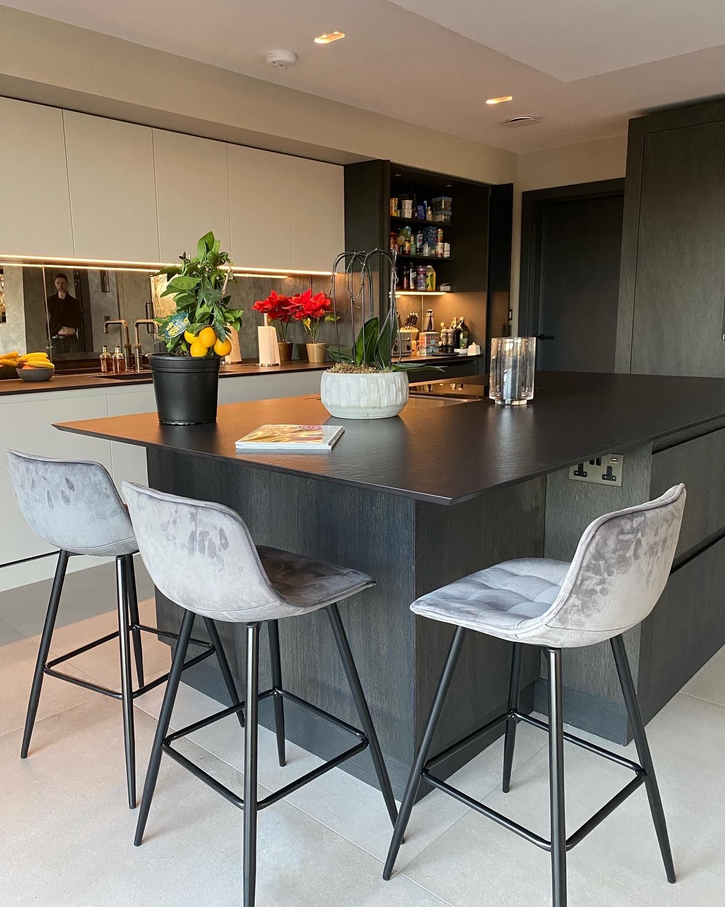 a luxury handmade kitchen with a black counter top and stools