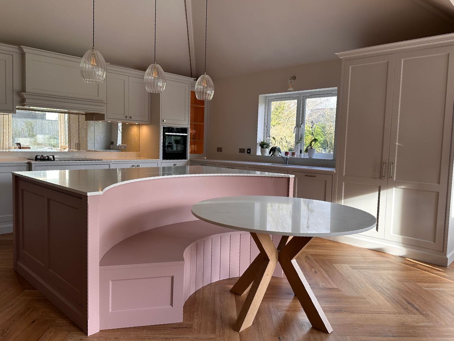 a luxury kitchen with a pink island and a white table