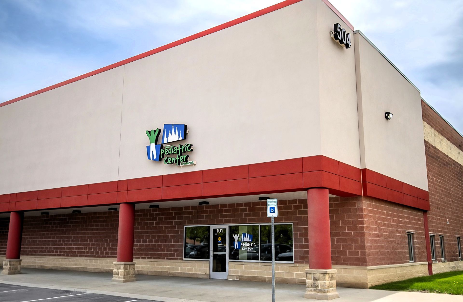 Exterior of a Walmart store with red brick and beige facade, front entrance visible