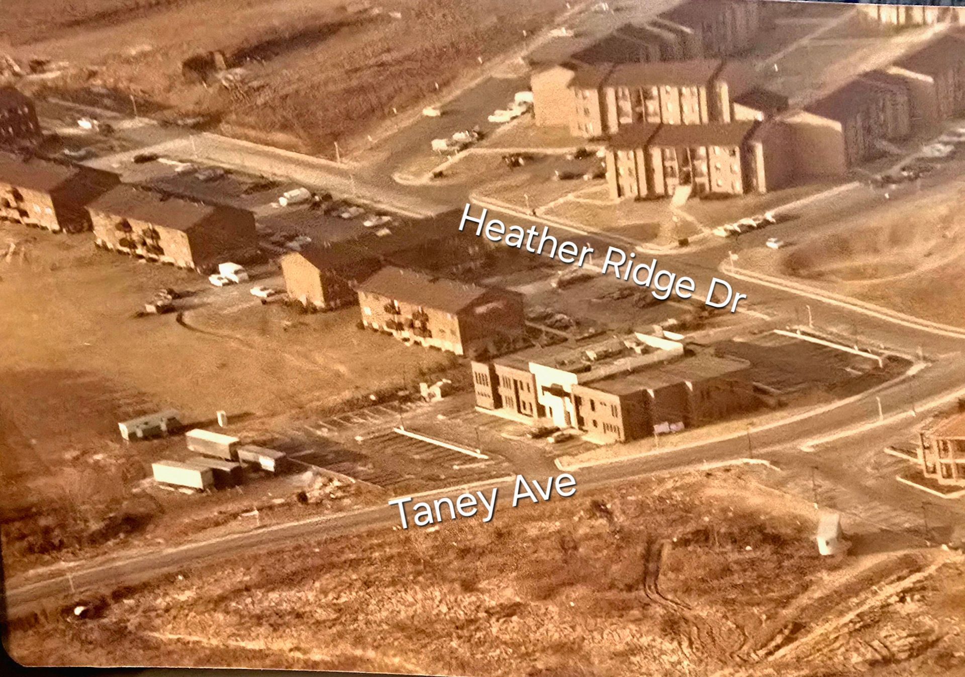 Aerial view of an intersection with labeled streets, buildings, and roads in a dusty suburban area.