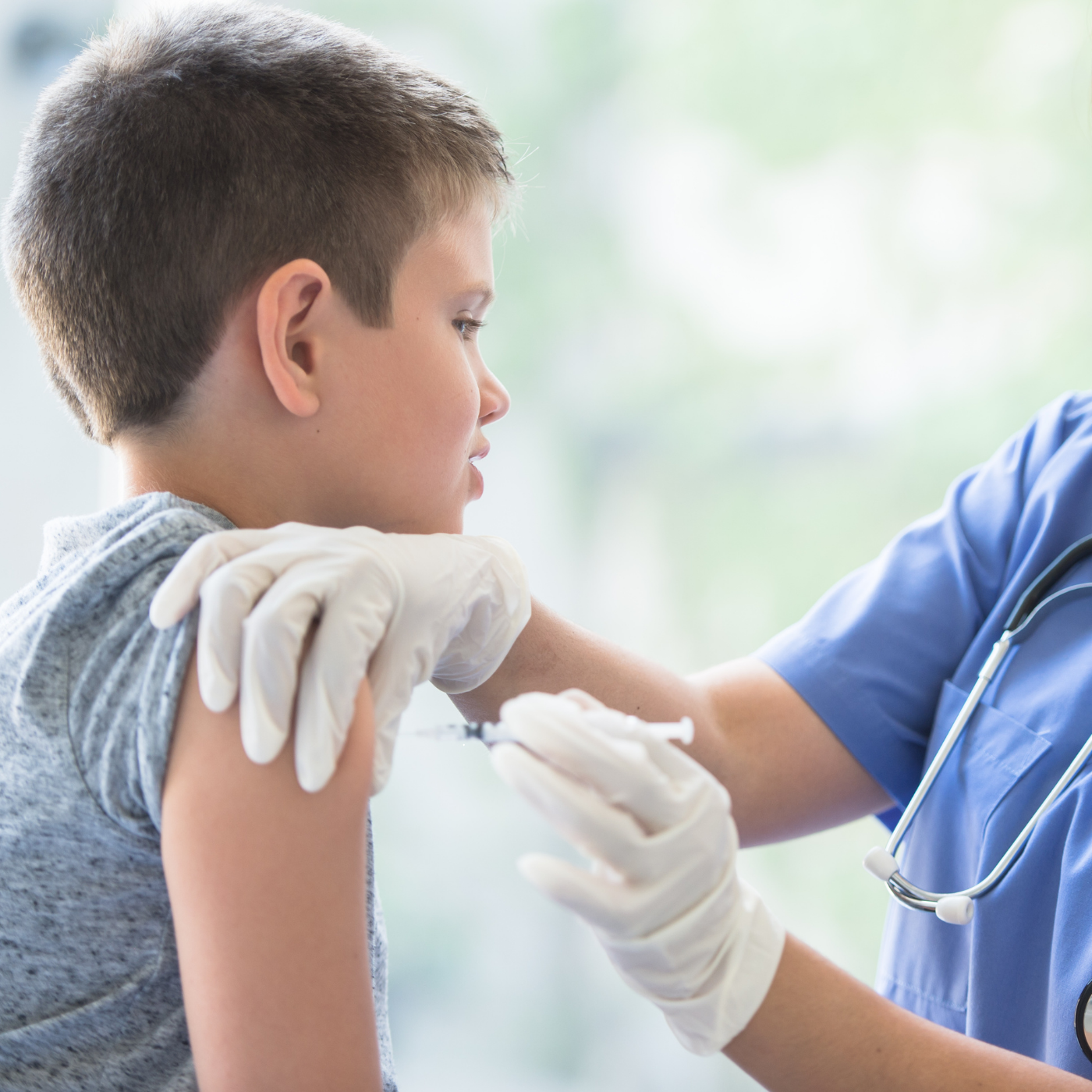 Healthcare worker giving a child an injection in a bright clinic