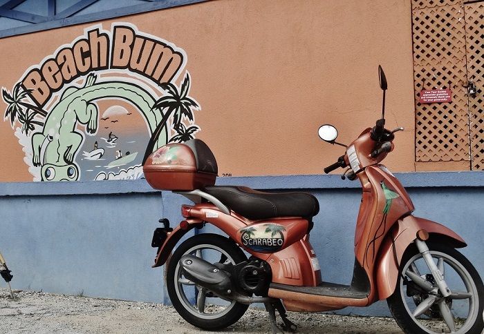Near to our properties to buy or rent in the Cayman Islands. Orange scooter parked outside 