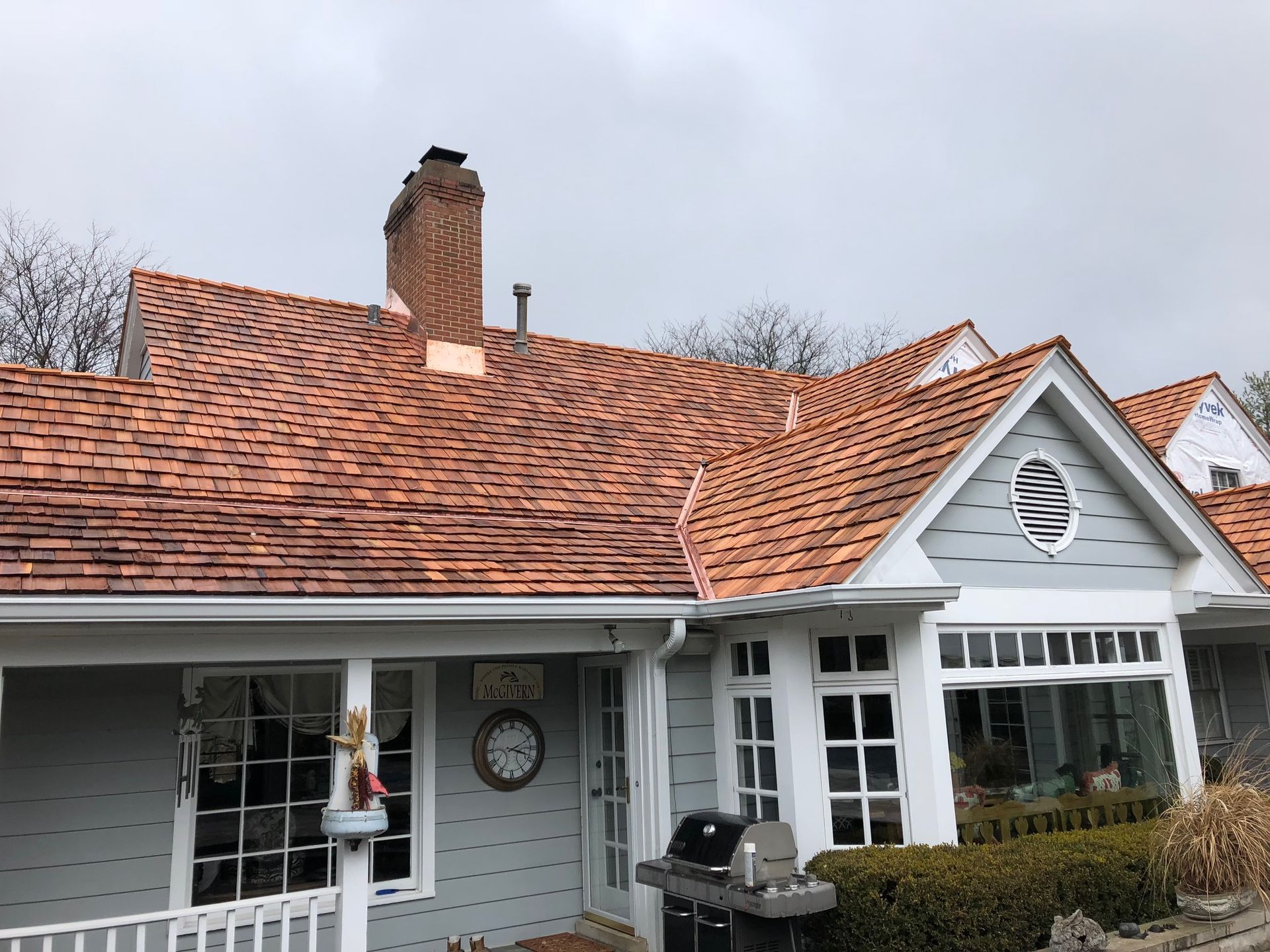 A white house with a red tile roof and a chimney.