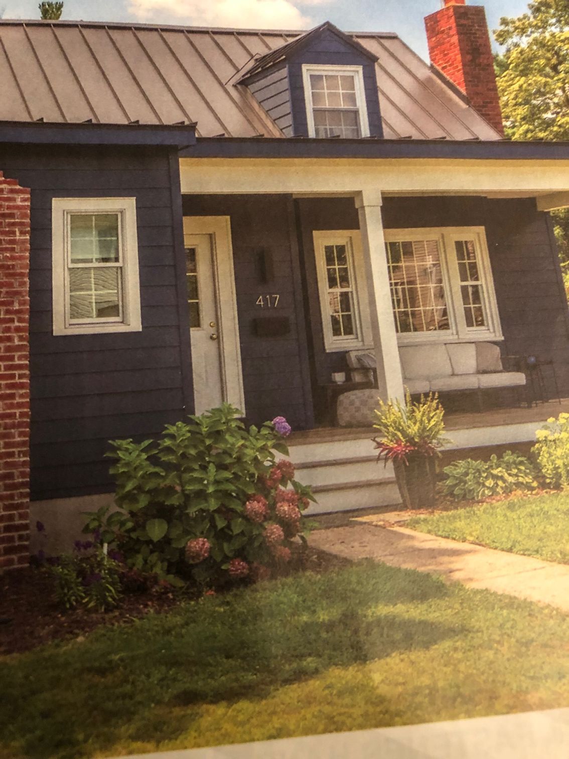 A picture of a blue house with a porch