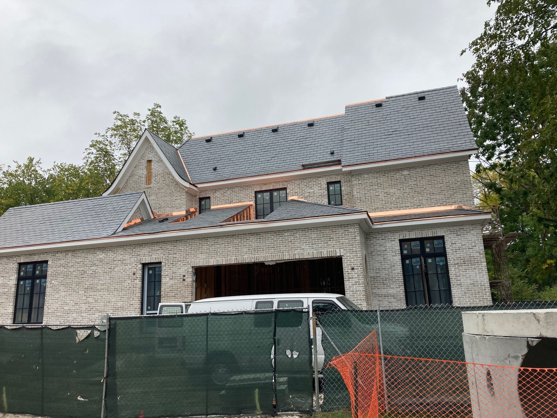 A house under construction with a van parked in front of it.