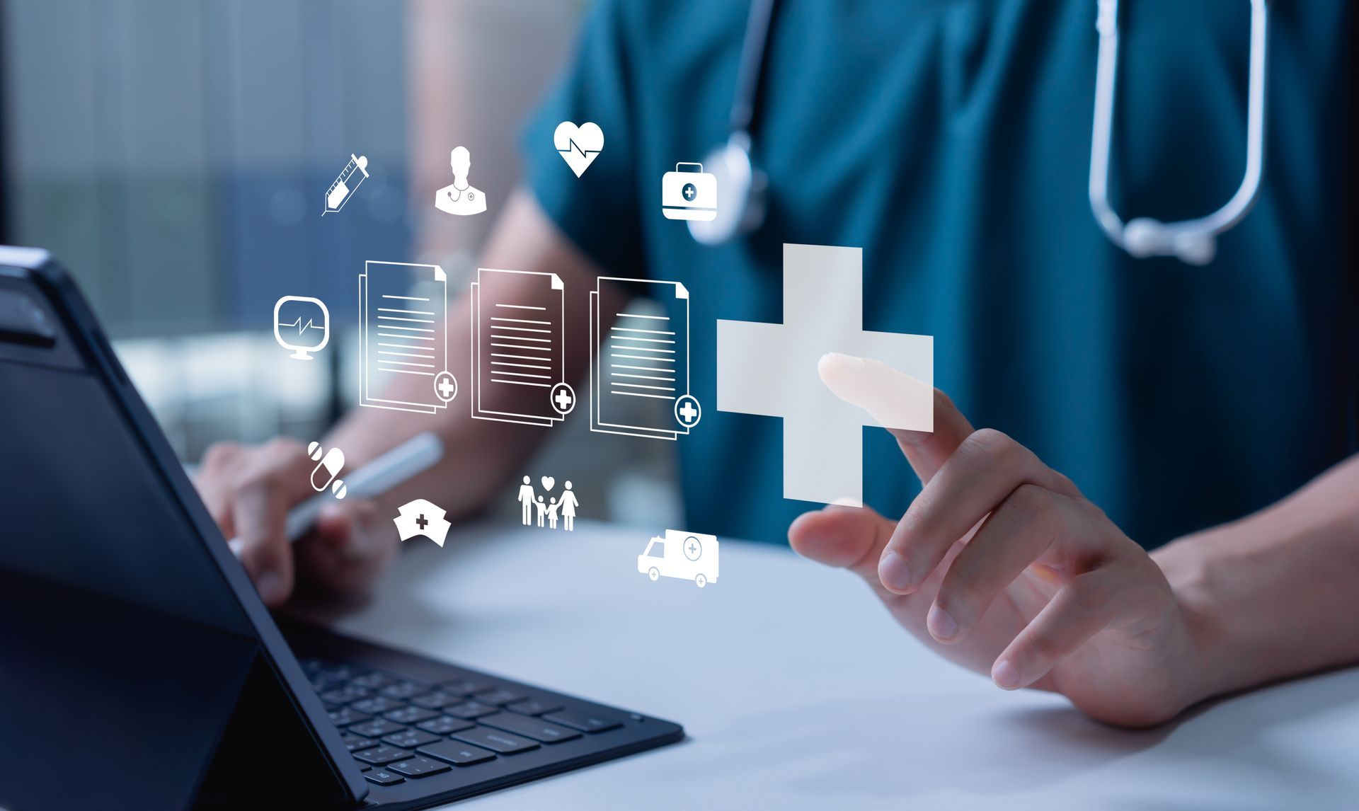 Healthcare worker tapping digital medical icons beside a laptop