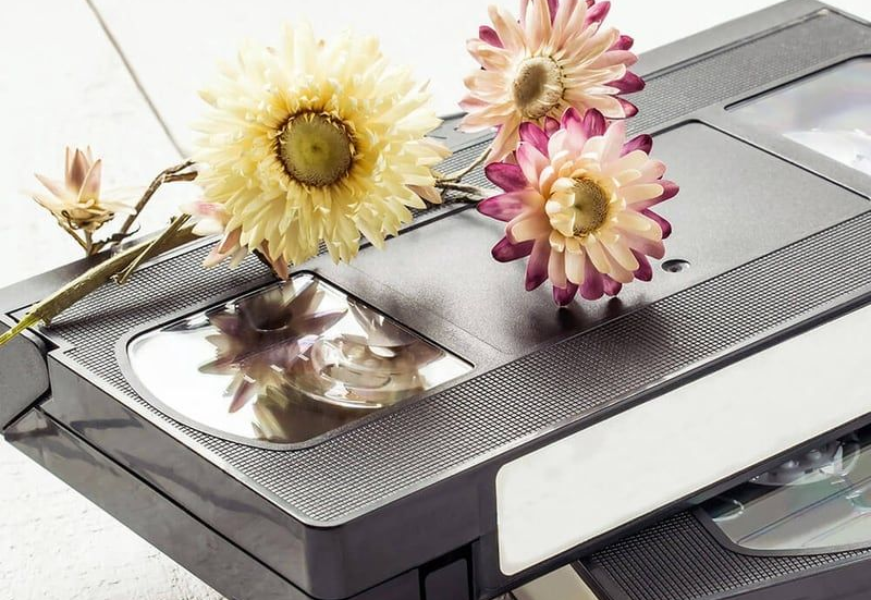 Flowers arranged on a metallic printer, with a paper tray and a printed floral image beneath.