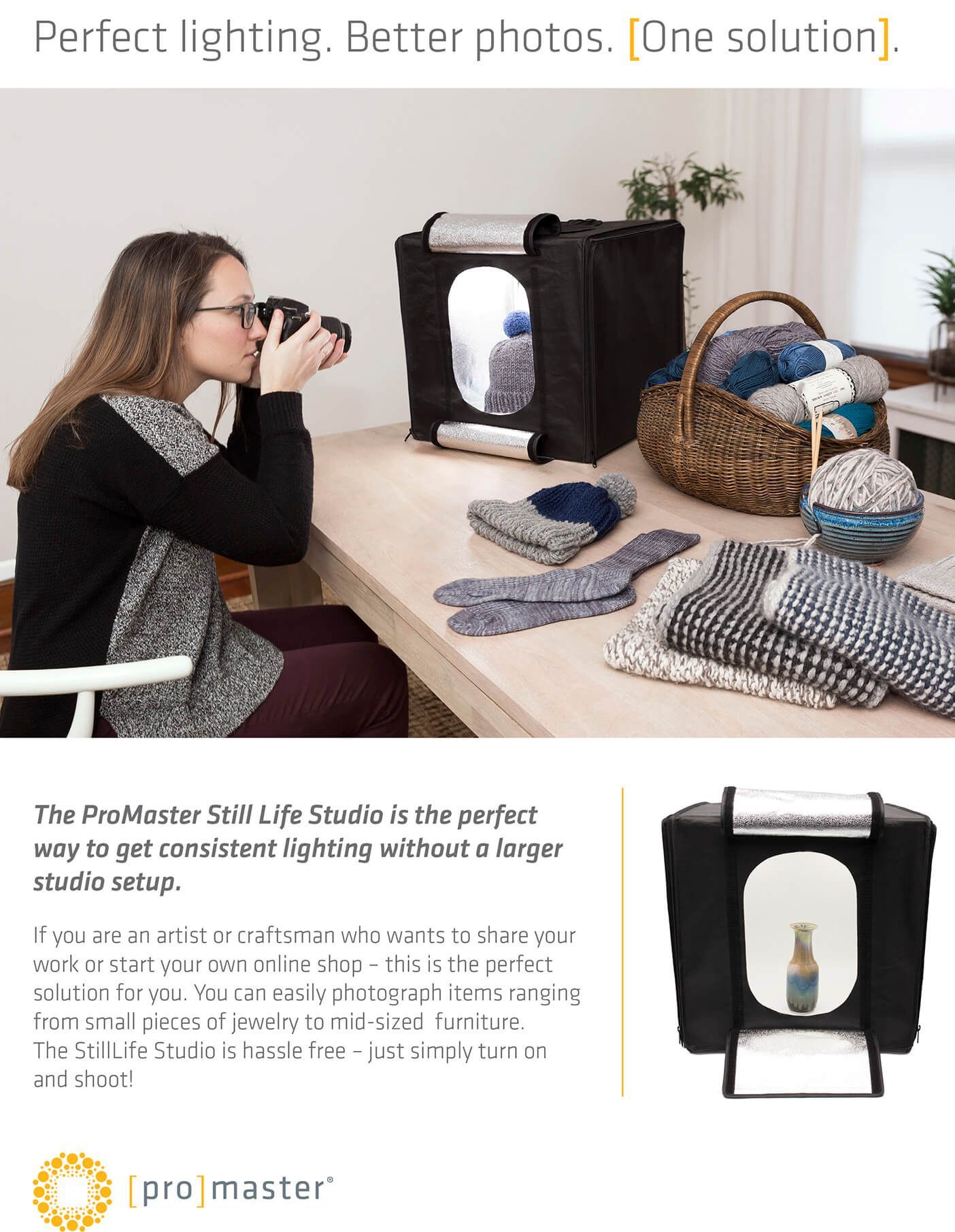 Woman photographing clothes lit inside a portable lightbox on a tabletop, with folded garments nearby