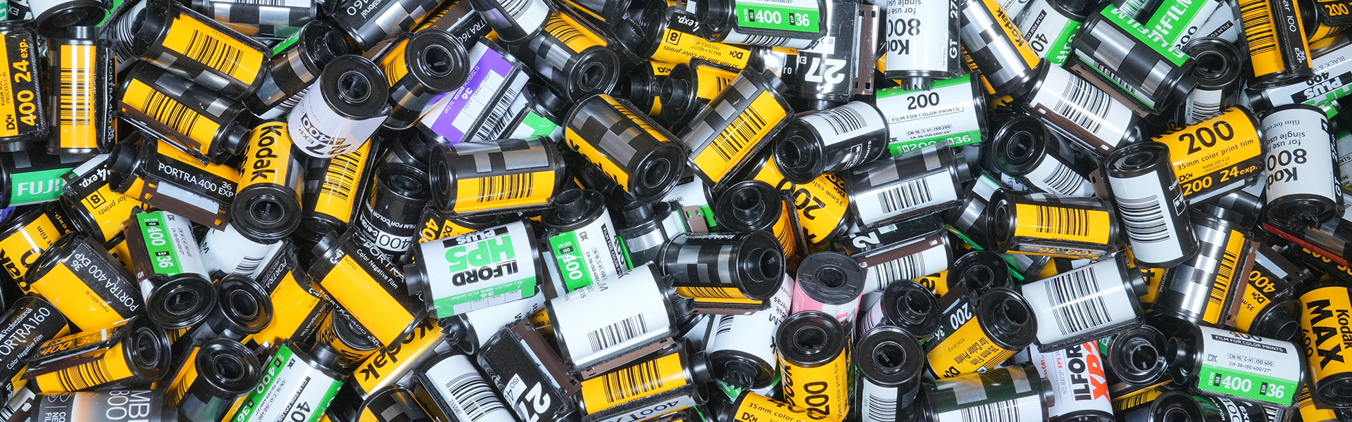 A pile of small battery cells and wrappers in black, silver, yellow, and white