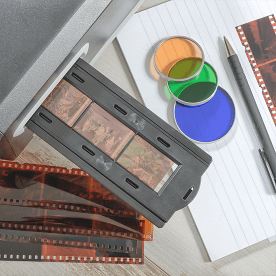 Film negatives, a slide holder, and colorful lens filters on lined paper