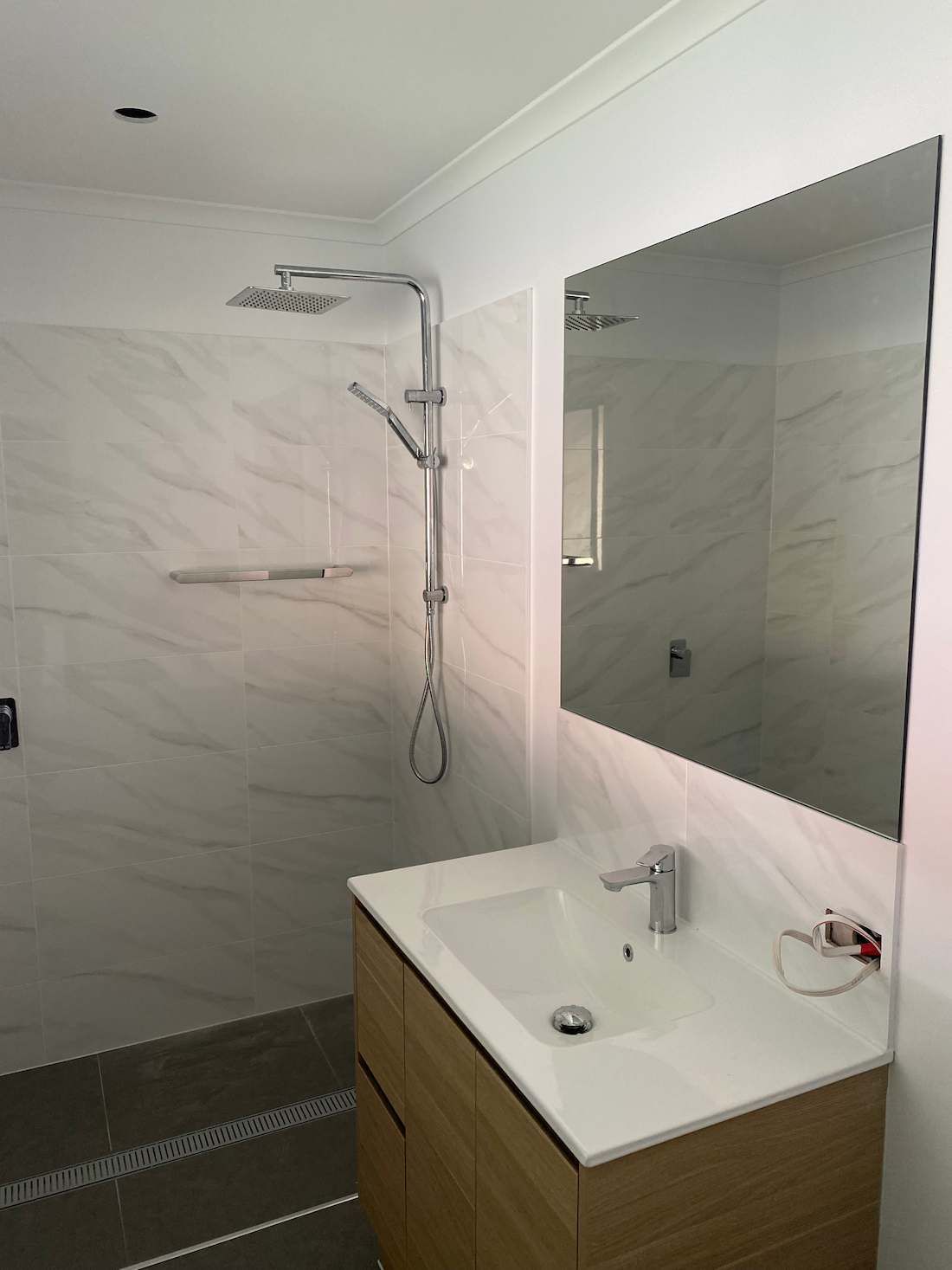 A Bathroom with A Sink , Shower and Mirror — Nick Hall Builder in Coolum, QLD