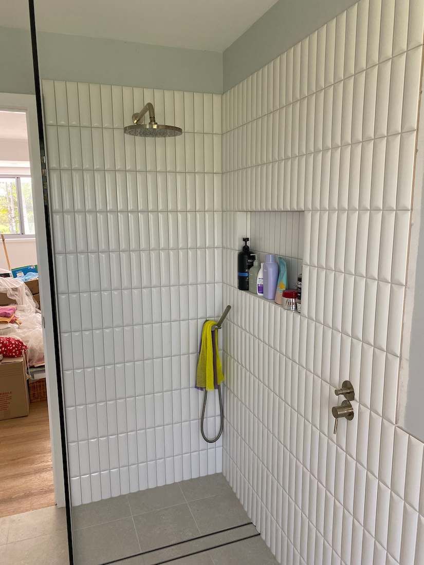 A Bathroom With White Tiles and a Shower — Nick Hall Builder in Noosa, QLD