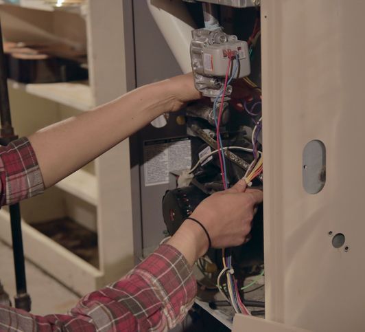 Hands working on furnace