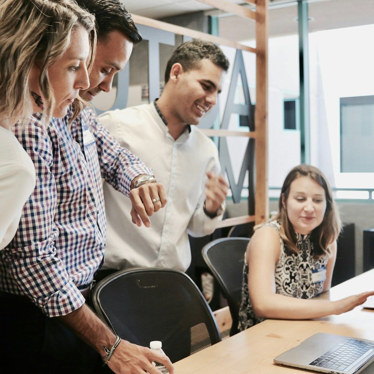 A group of people are looking at a laptop computer