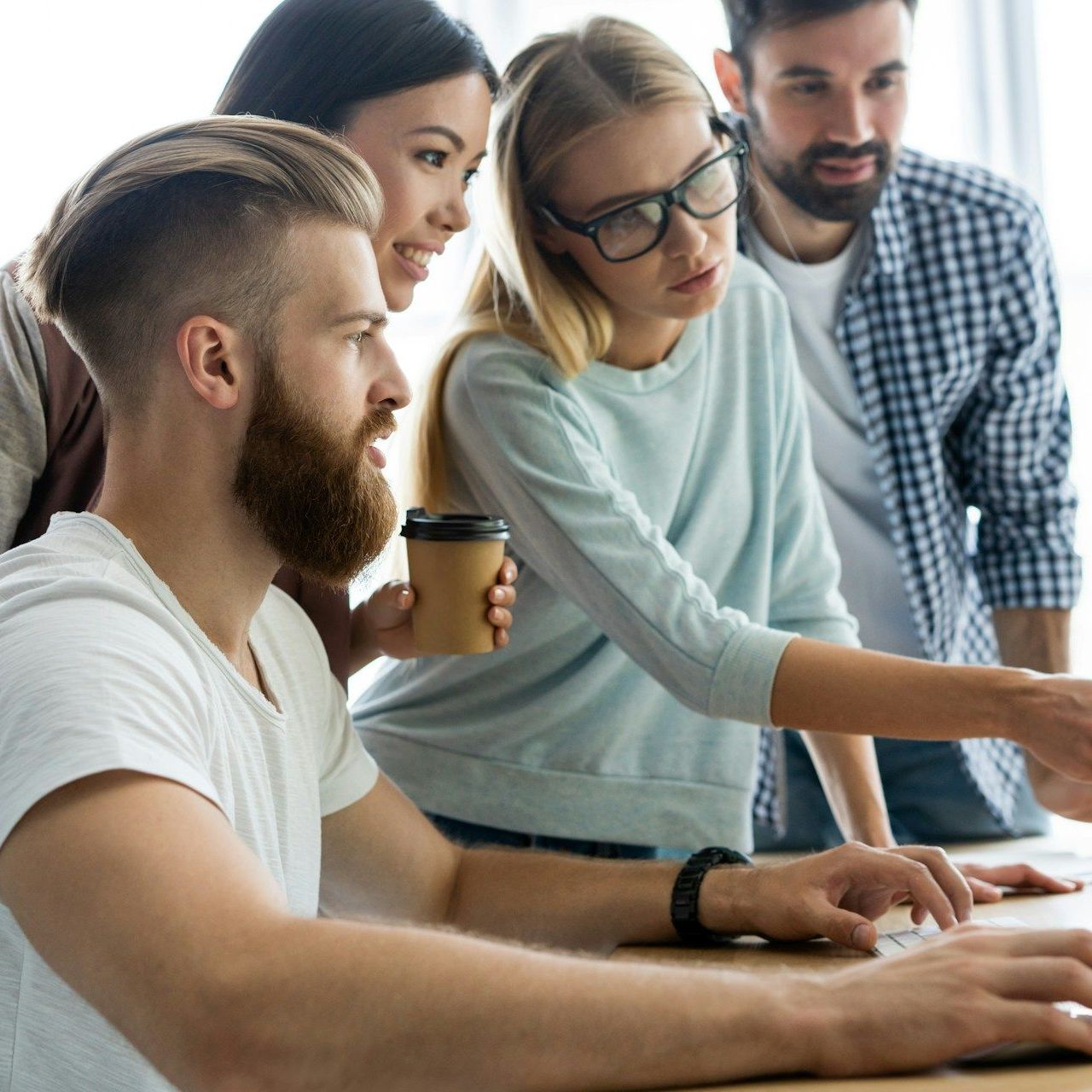A group of people are looking at a computer screen