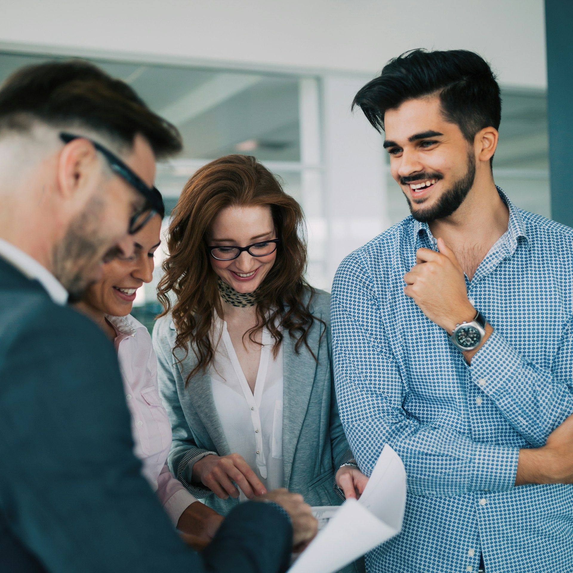 A group of people are standing around a table looking at a piece of paper.