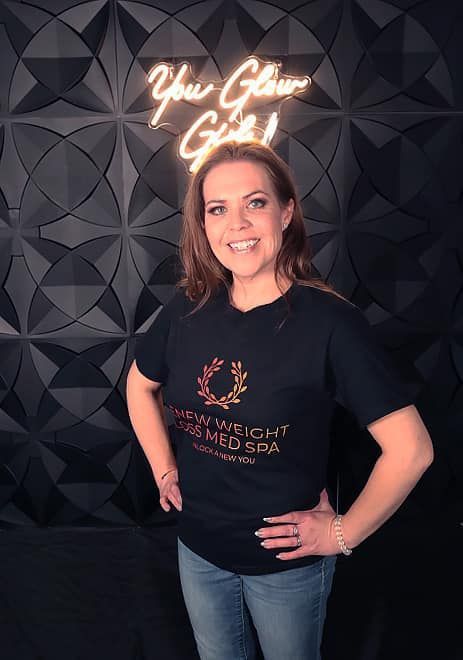 A woman is standing in front of a neon sign that says `` you glow girls ''.