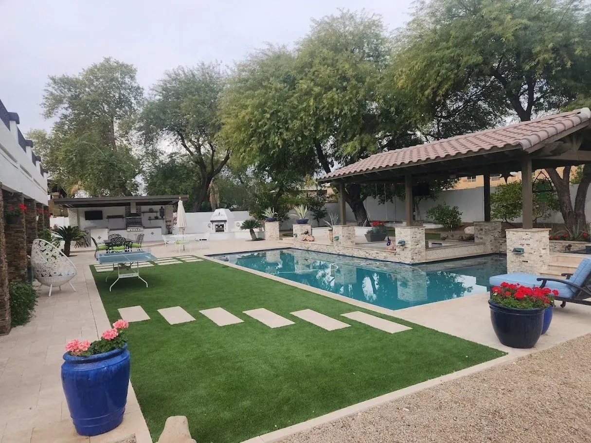 Backyard pool with lawn, stepping stones, and shaded patio under trees