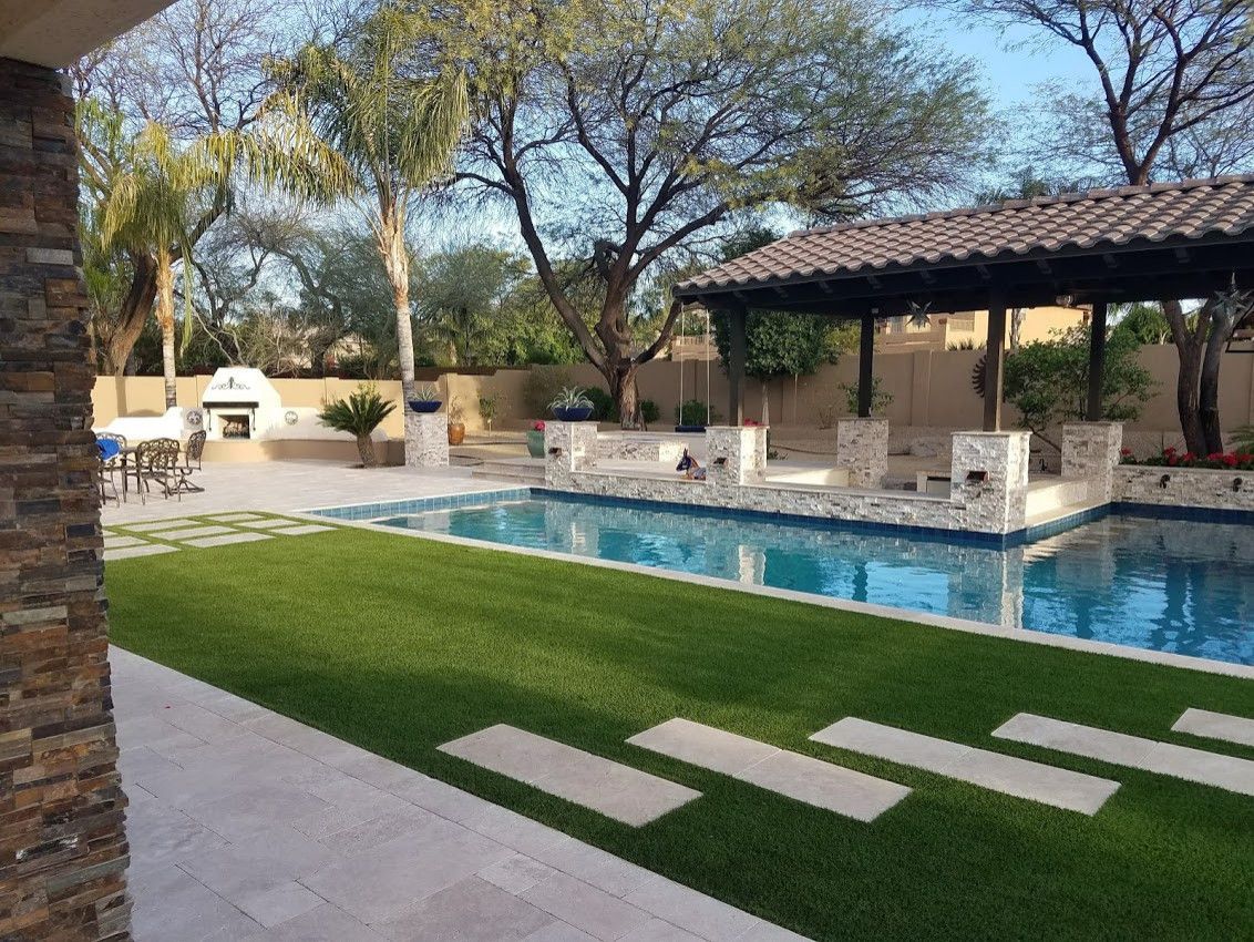 There is a large swimming pool in the backyard of a house.