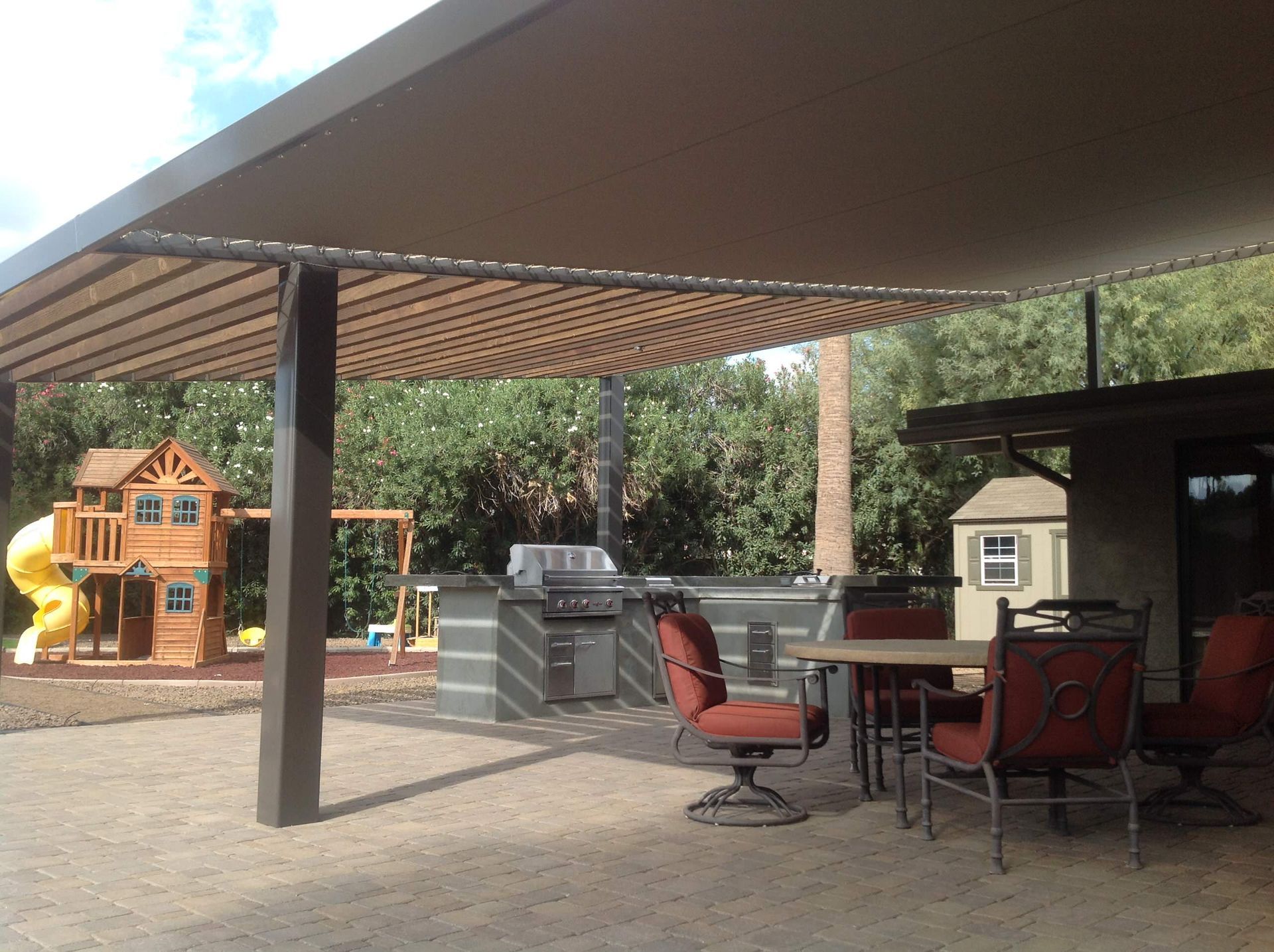 A patio with a table and chairs under a canopy