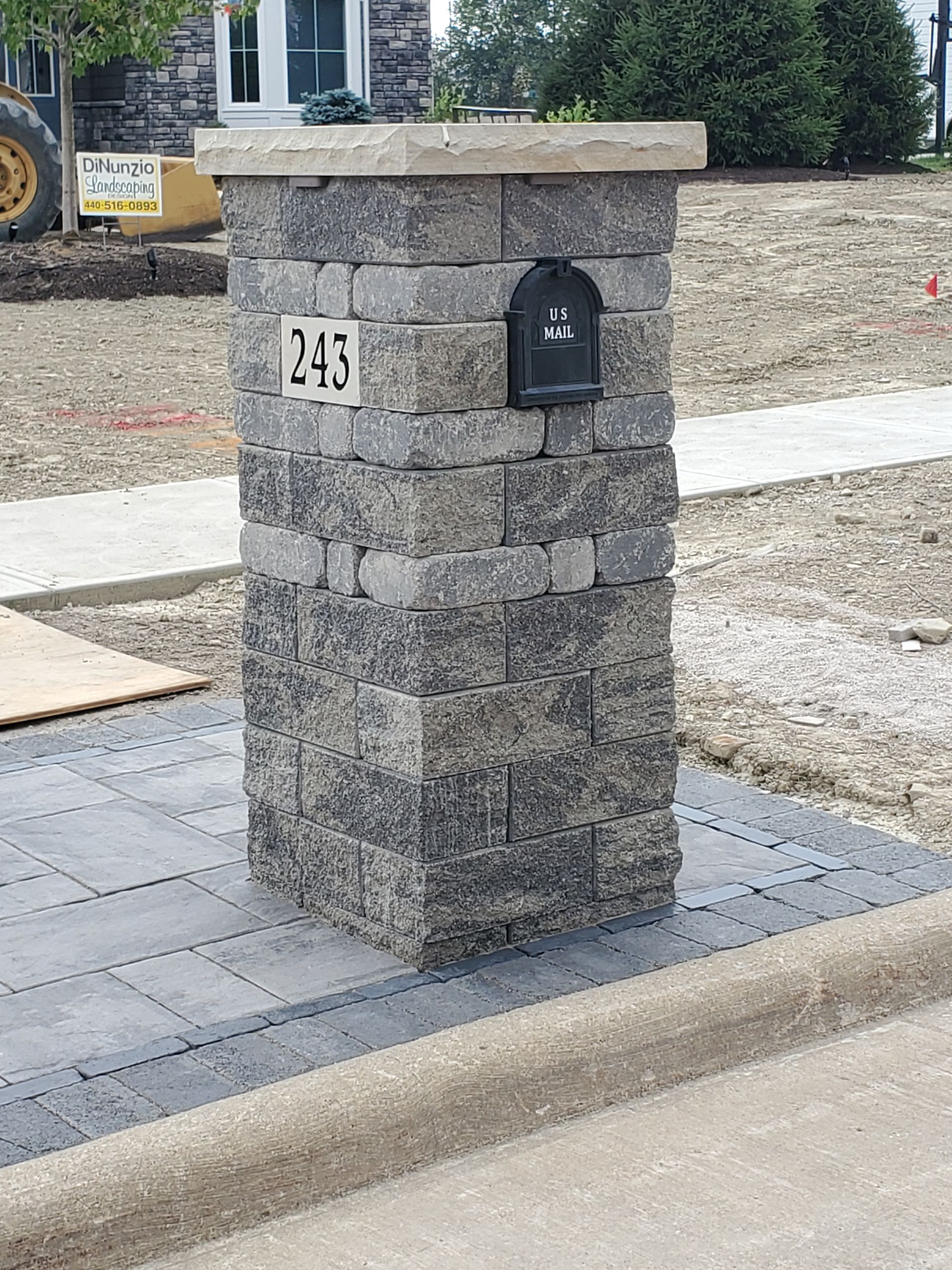 A brick post with a mailbox attached to it.