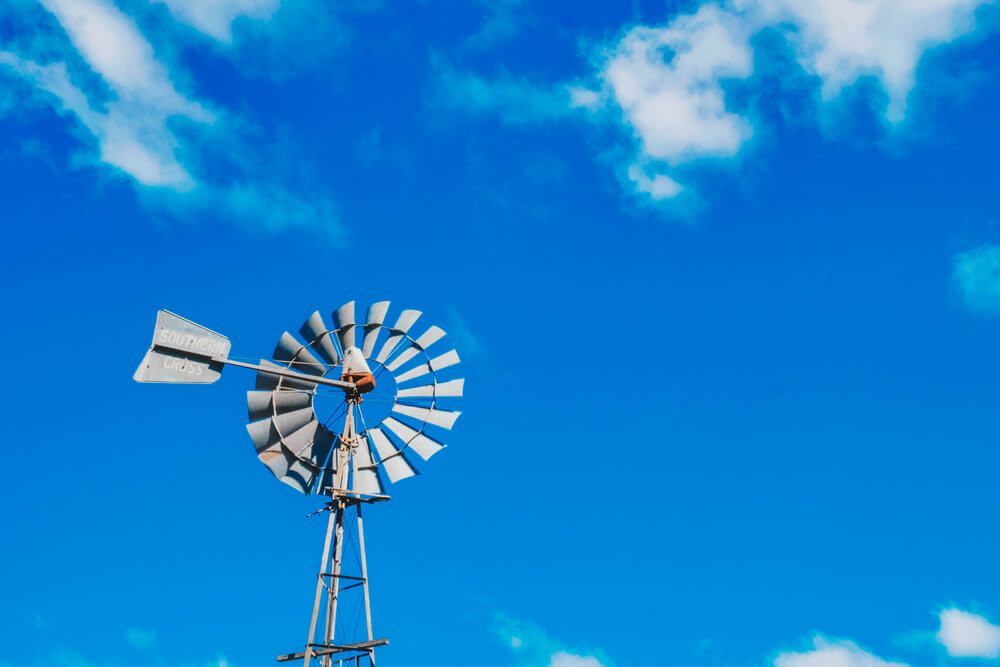 A Windmill is Against a Blue Sky With Clouds — Nelson Keane & Hemingway Lawyers in Dubbo, NSW