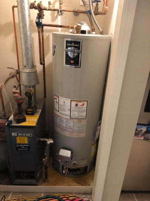 A natural gas water heater and furnace in a utility room.