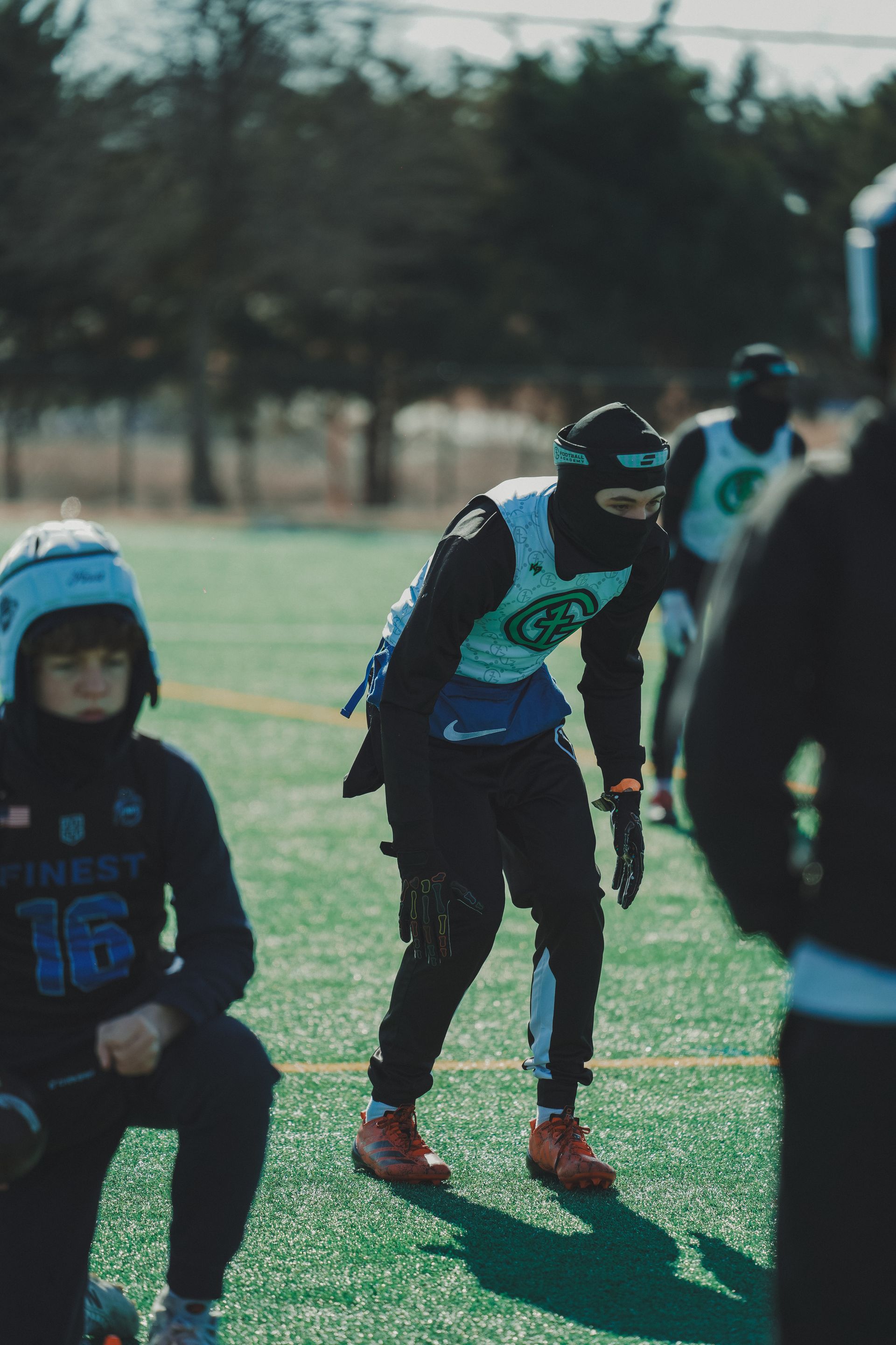 Children in sports gear running on a grassy field during an outdoor game
