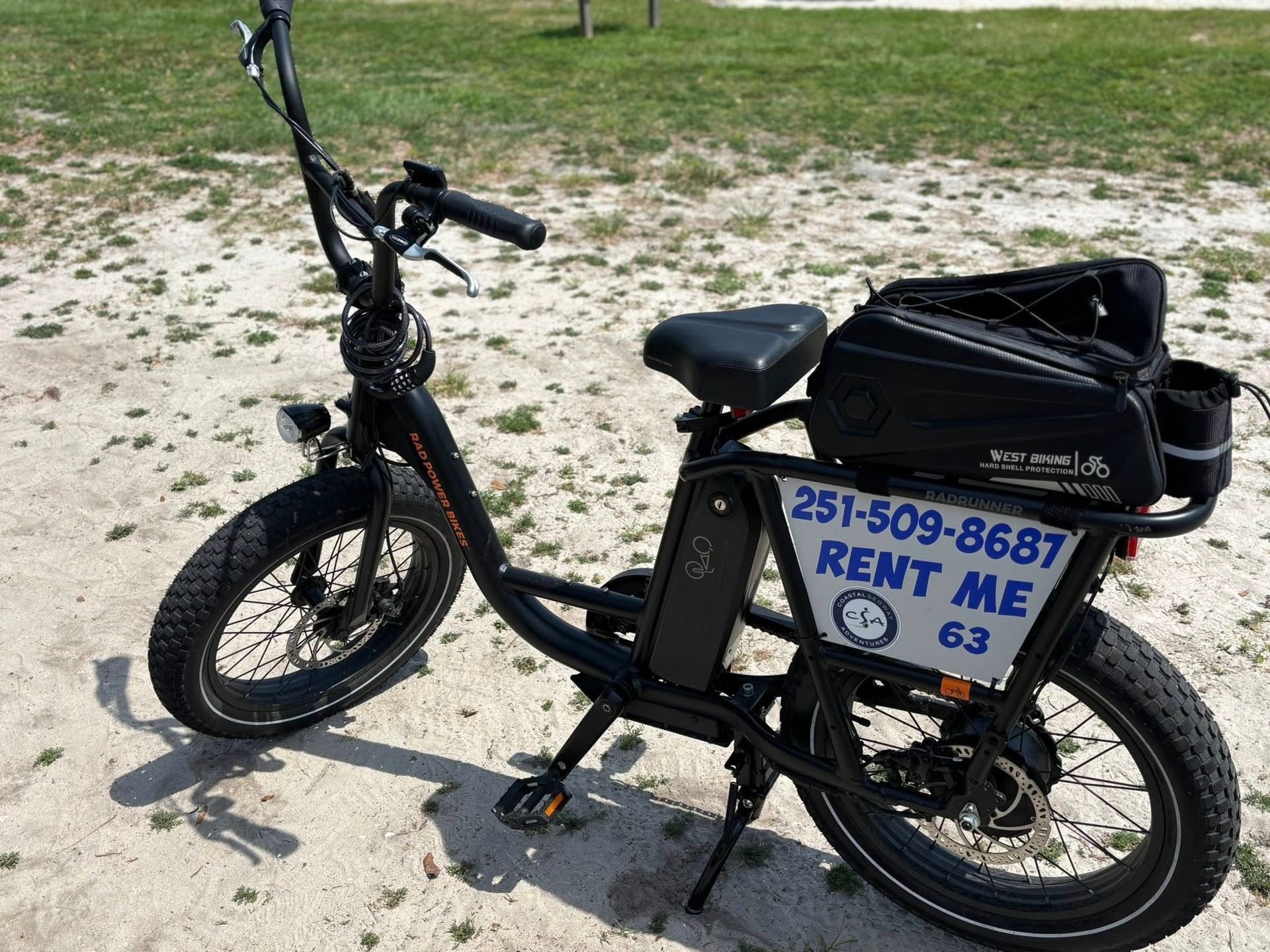 Black electric bike on sandy ground, with a
