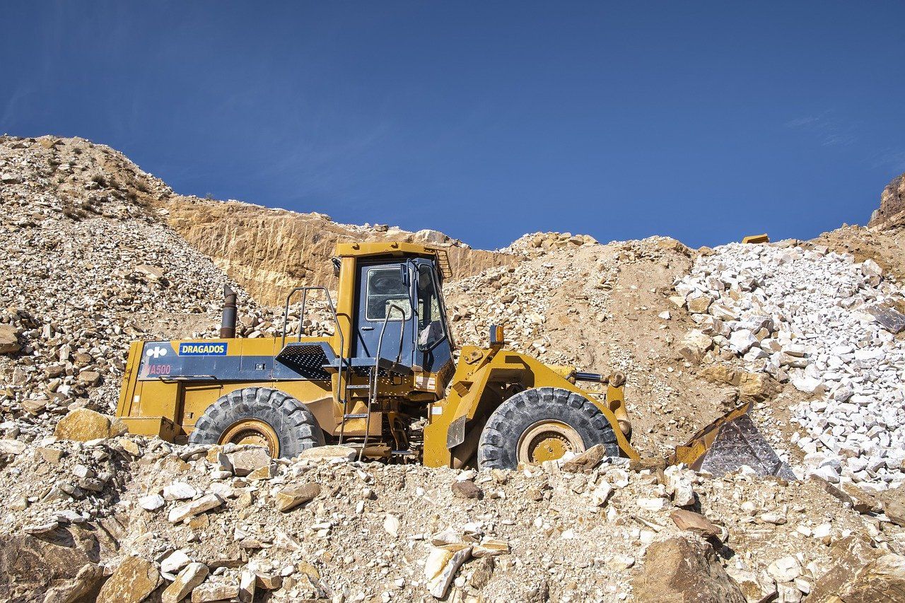 a wheel loader sits in a pile of rocks