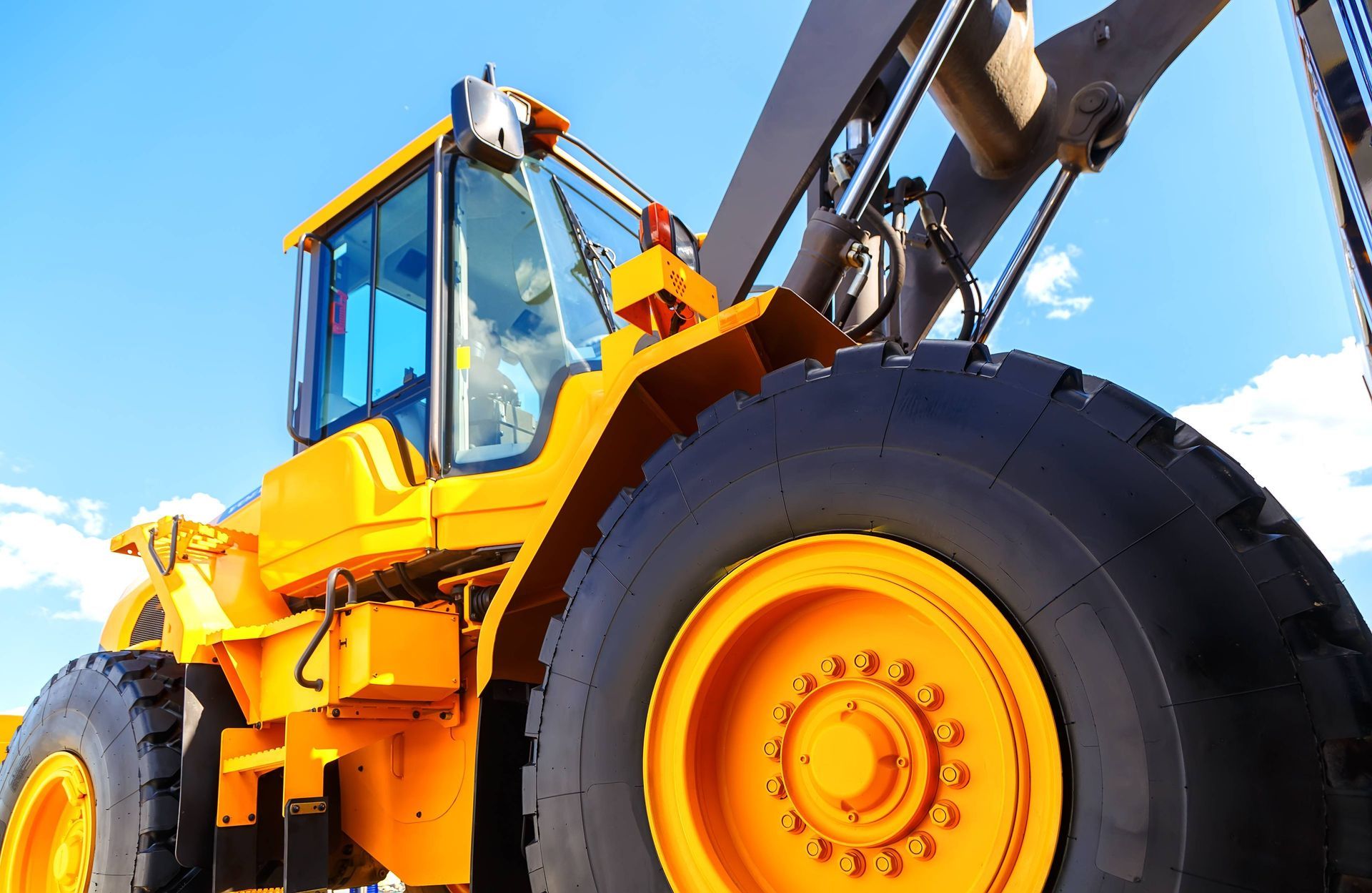 a large yellow tractor with a blue sky in the background