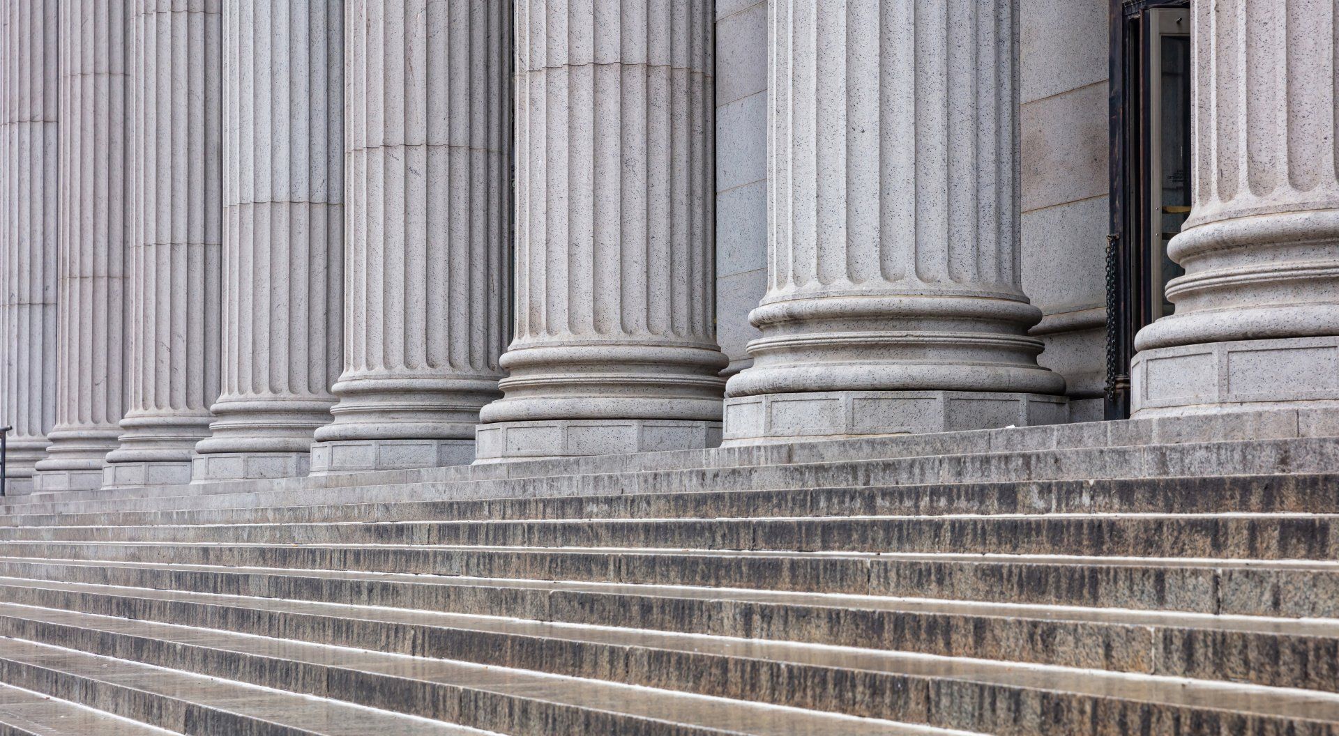 A row of columns and stairs in front of a building.