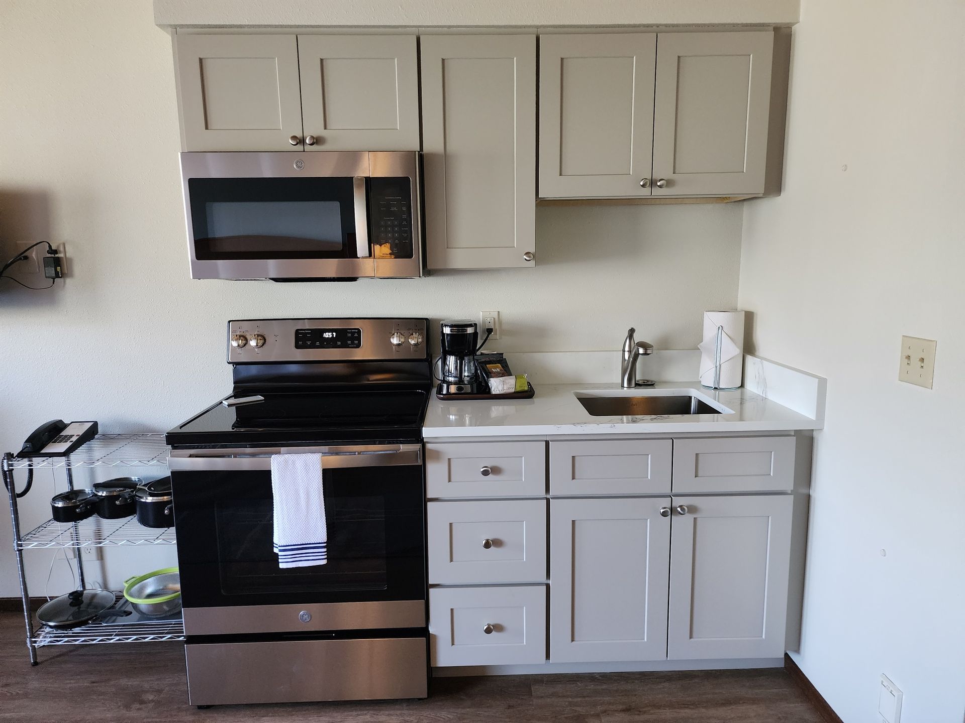 Small kitchen with gray cabinets, stainless steel appliances, and white countertop.