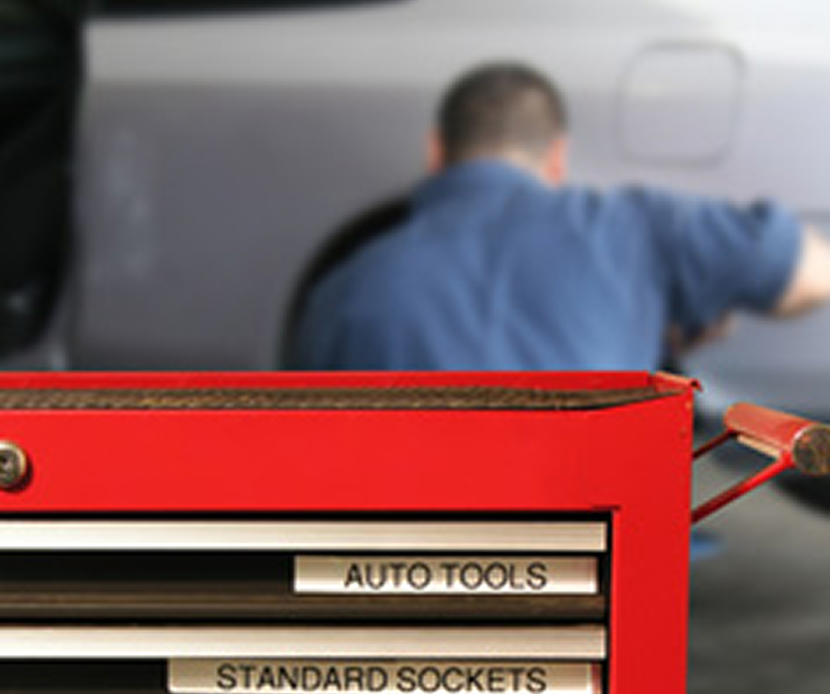 Red tool storage and a mechanic in the background | B & J Automotive