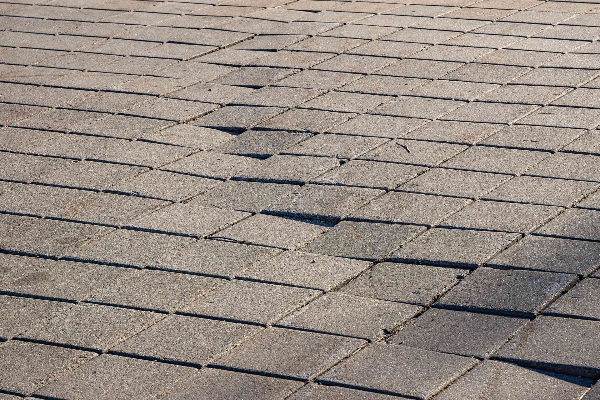 Close-up of a gray shingled roof with visible cracks and damaged sections