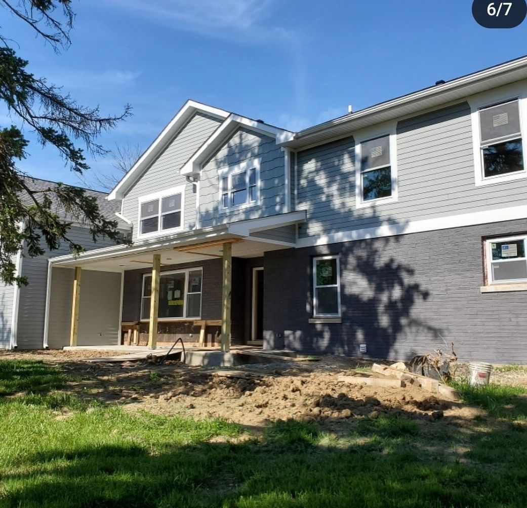 A large house with a porch and a lot of windows