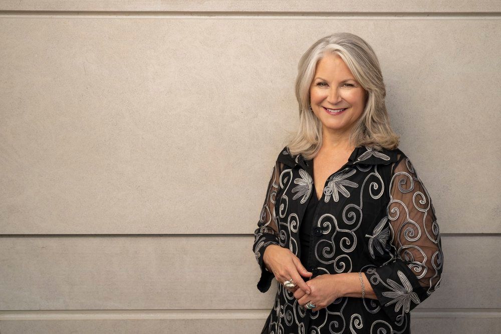 picture of patrice michaels, a white woman with long grey hair, smiling at the camera