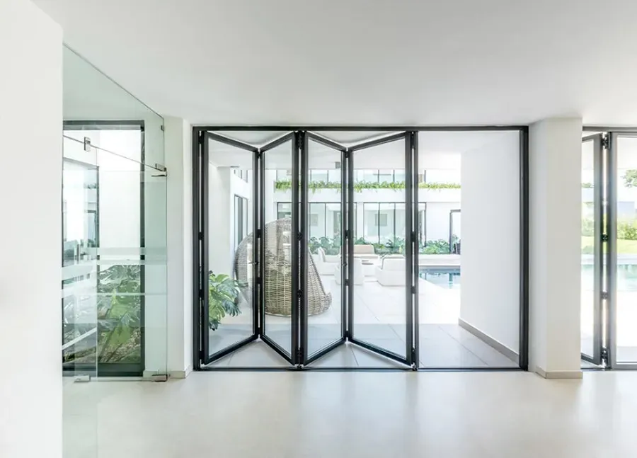 A room with a lot of windows and a bifold glass door.