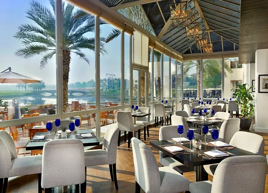 A restaurant with tables and chairs and a view of the water