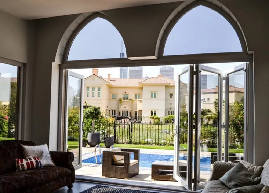 A living room with a view of a house and a pool