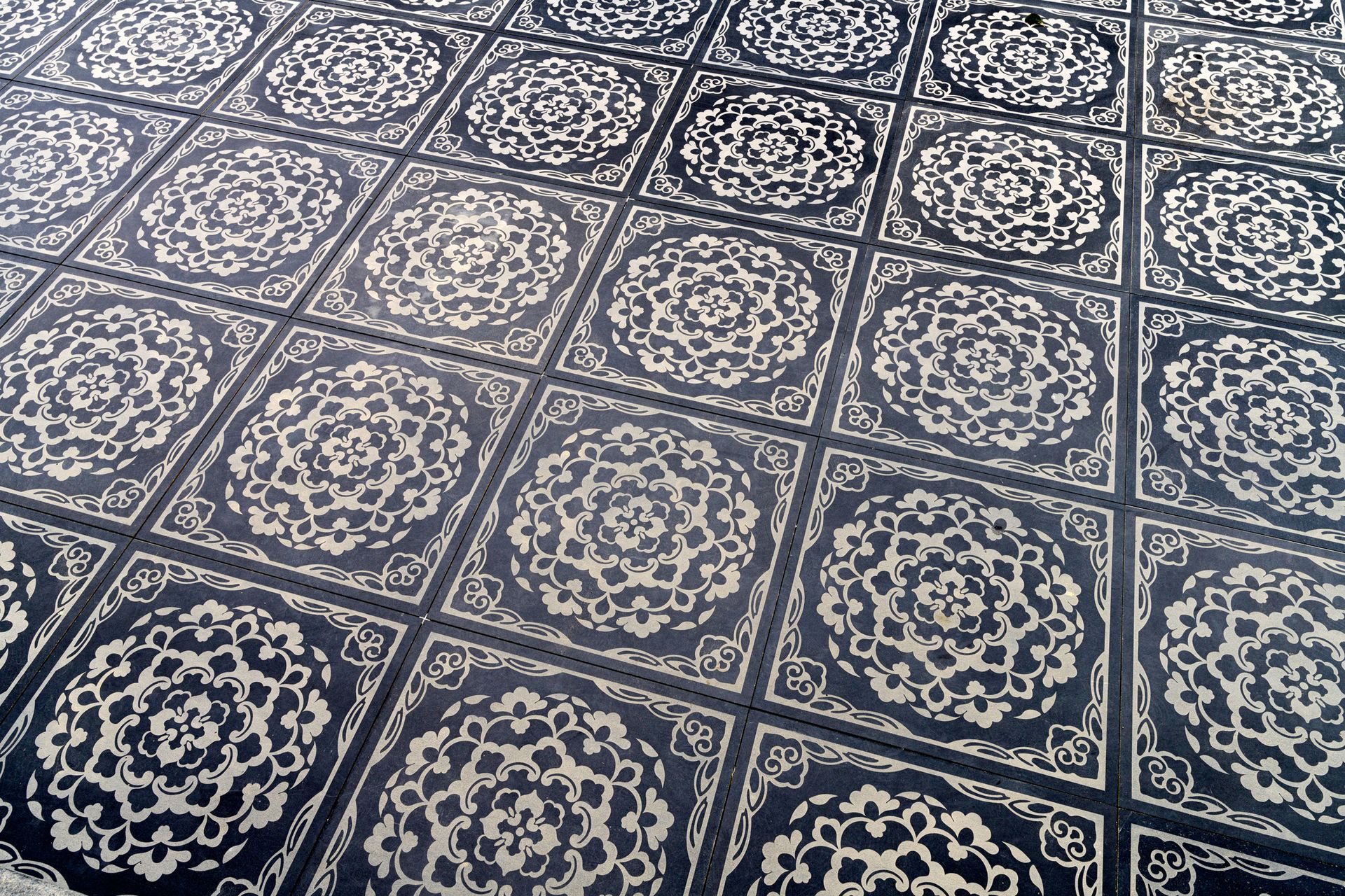 Dark patterned floor tiles with ornate, circular designs.