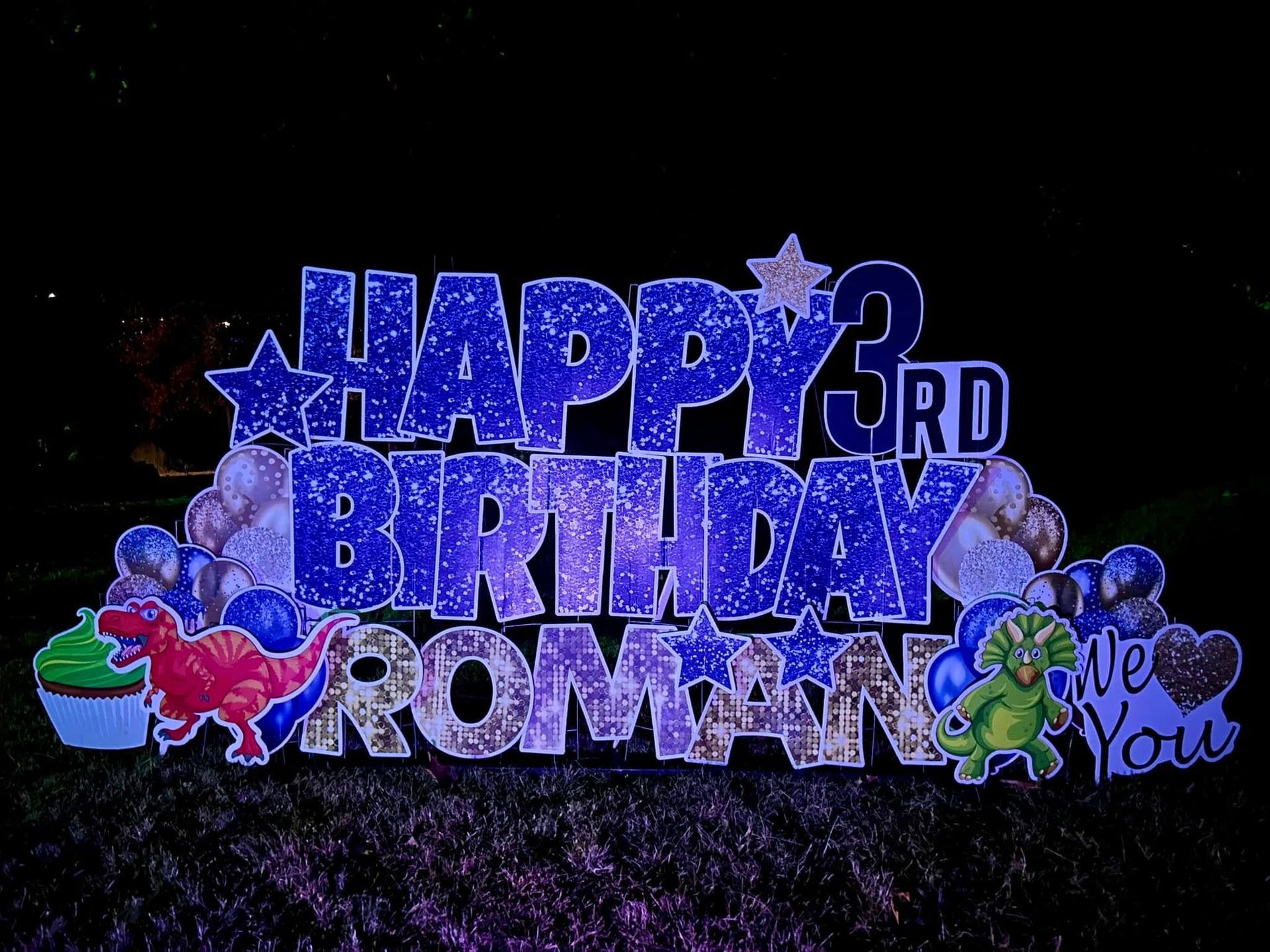 Colorful “Happy 3rd Birthday Roman” balloon display with stars, hearts, and cartoon characters on a black background