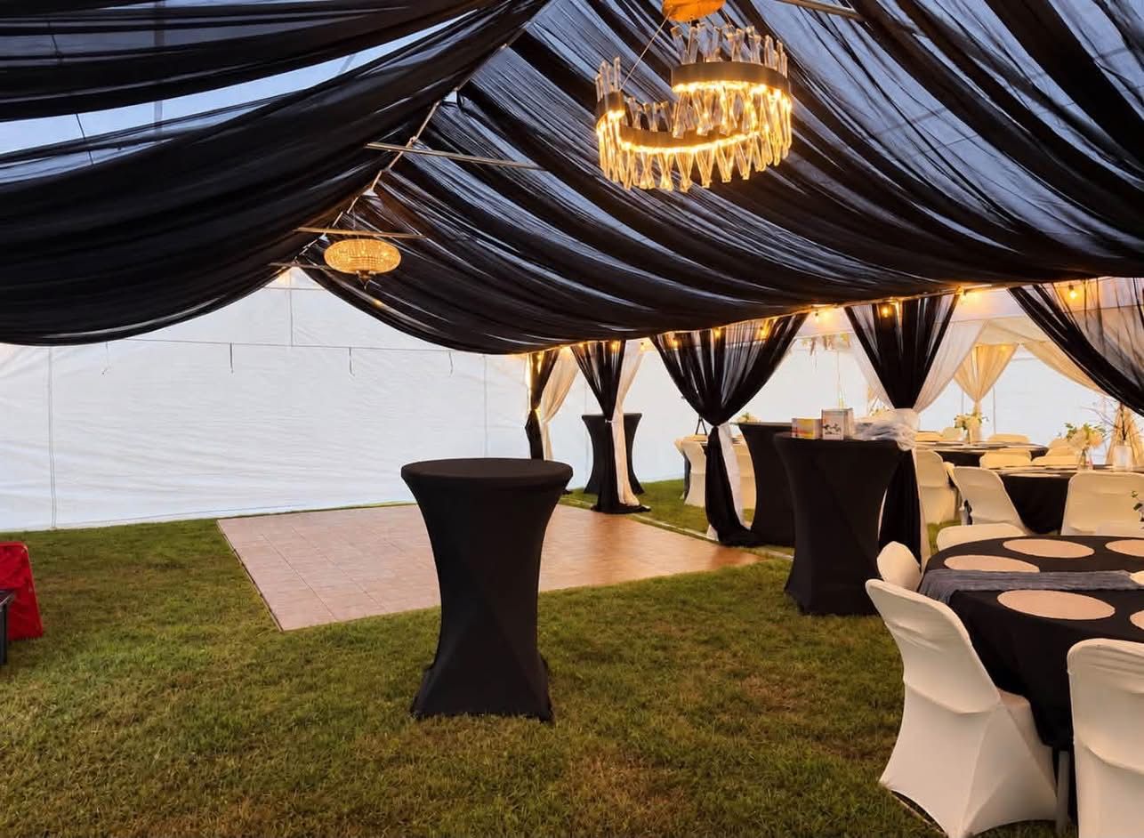 Cocktail tables with linens set up at an outdoor wedding event.