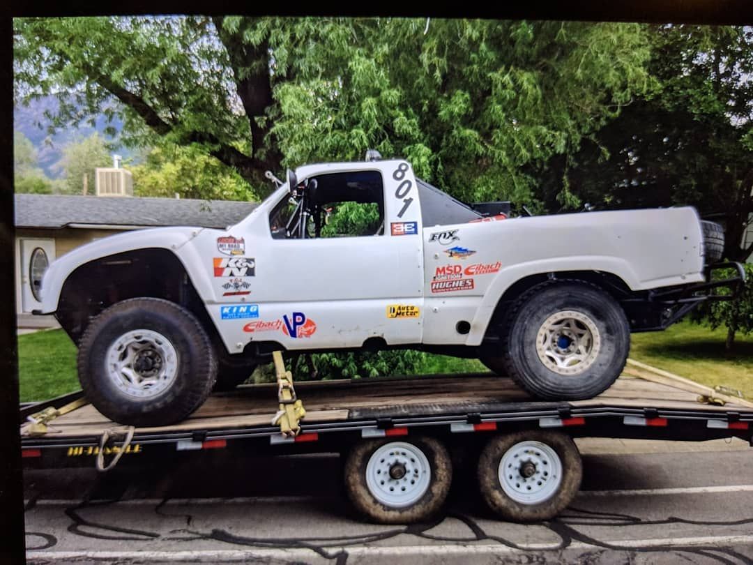 A white truck is sitting on top of a trailer