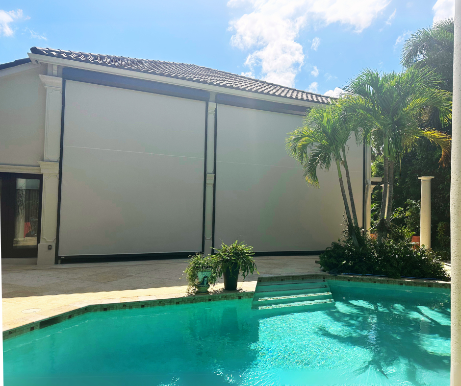 Exterior of a house with pool. Large white sun shades cover a section of the house on a sunny day.
