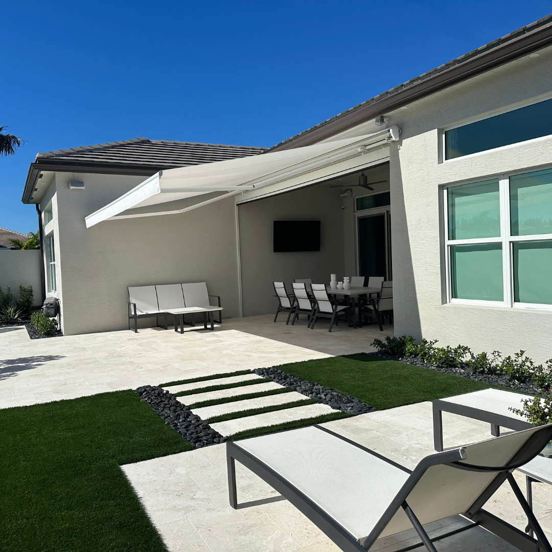 Backyard patio with retractable awning, seating, dining area, and a path of stepping stones.