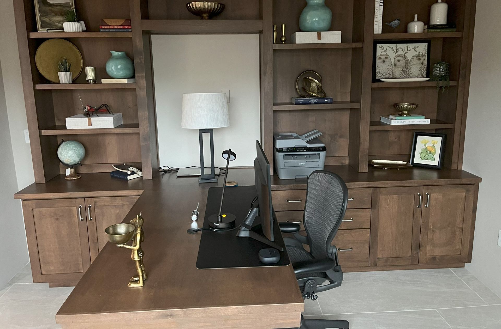 A home office with a desk a chair and shelves